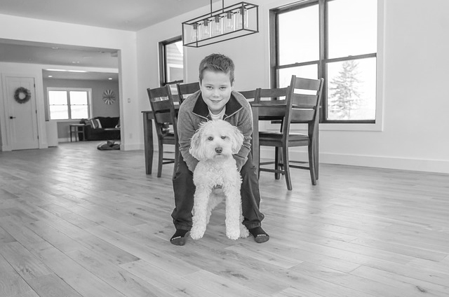 Young boy holding his dog inside the home